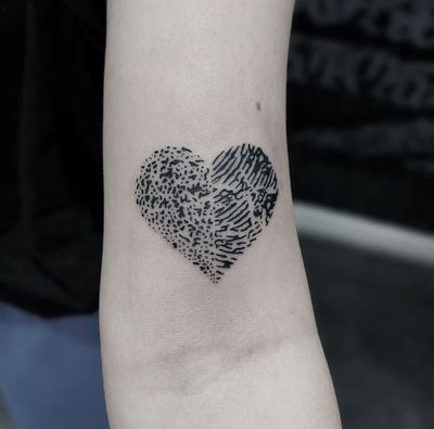 Discover the beauty of love and identity with this illustrative tattoo by Tom Boxell, showcasing a heart intertwined with a fingerprint design.