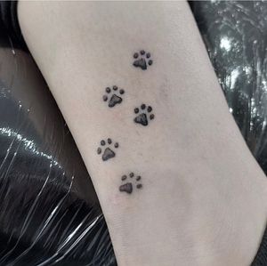 Experience the striking beauty of an illustrative paw print tattoo skillfully created by Tom Boxell.