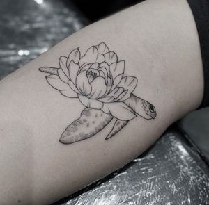 Beautiful fine line illustrative tattoo of a turtle with a flower, by artist Tom Boxell. Elegant and intricate design.