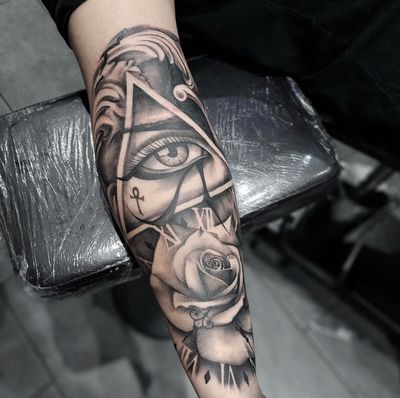 Beautiful black and gray tattoo featuring a detailed rose, triangle, and clock design, by Tom Boxell.