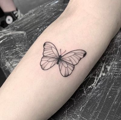 Admire the intricate details of this fine_line, illustrative butterfly tattoo created by the talented artist Tom Boxell.