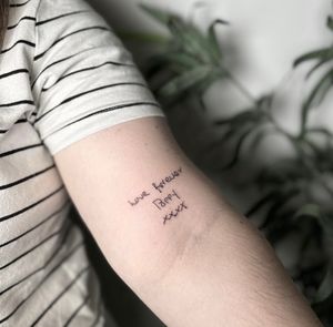 Get a stunning small lettering tattoo with intricate fine line details by renowned artist Tom Boxell. Perfect for a subtle and elegant design.