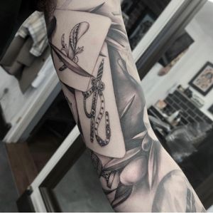 Discover the intricate details of this black and gray tattoo featuring realistic cards, expertly executed by Tom Boxell.