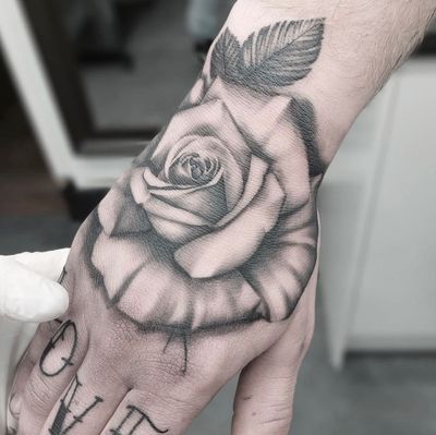 Experience the beauty of a lifelike black & gray rose tattoo by renowned artist Tom Boxell. Perfect for those who appreciate stunning floral detail.