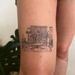 Illustrative tattoo of a living room with couch, table, and chair by Emily Bonnet. Perfect for homebody vibes.