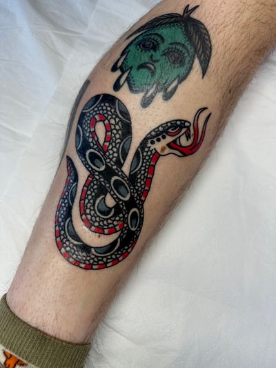 Experience the timeless art of traditional tattooing with this striking snake design by the talented Jakob Isaac.