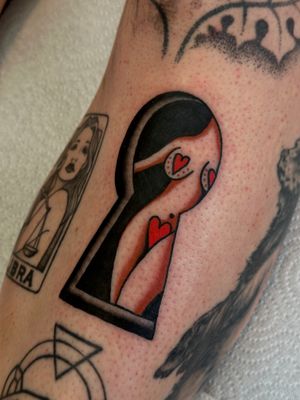 Get a classic pinup girl peeking through a keyhole with Jakob Isaac's expert traditional tattoo style.