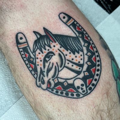 Capture the spirit of freedom with this timeless tattoo by Jakob Isaac, featuring a majestic horse and lucky horseshoe design.