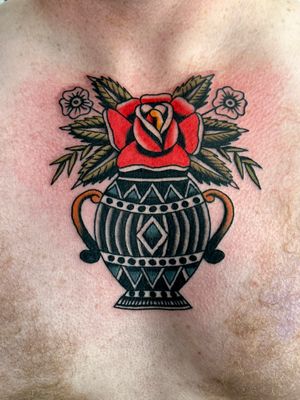 Beautiful traditional tattoo by artist Jakob Isaac featuring a gorgeous rose in a vase motif
