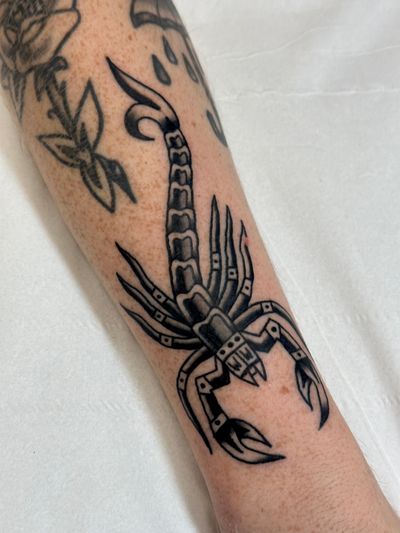 Get inked with a timeless traditional scorpion design by the talented artist Jakob Isaac. Bring out your inner strength and resilience with this striking tattoo.