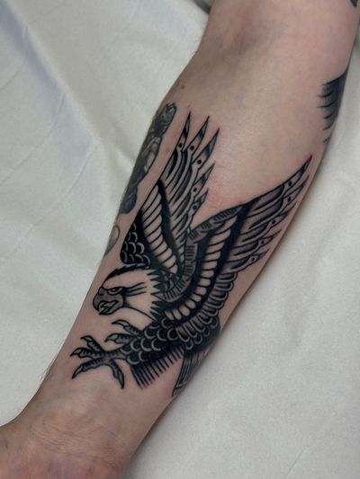 Experience the majestic beauty of a traditional eagle tattoo expertly crafted by Jakob Isaac. This timeless design symbolizes strength and freedom.