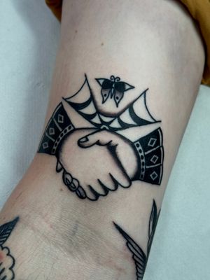 Get inked with Jakob Isaac's classic traditional handshake design, symbolizing trust and unity.