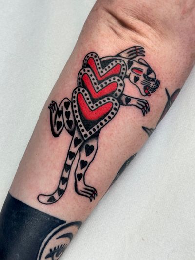 Get a fierce and timeless panther heart tattoo by the skilled artist Jakob Isaac. Embrace the power and passion in this traditional style design.