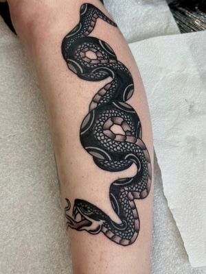 Get a bold and classic traditional snake tattoo by the skilled artist Jakob Isaac. This design symbolizes transformation and protection.