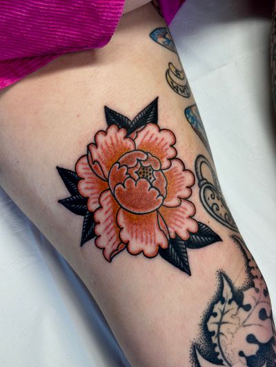 Get a timeless and vibrant traditional peony flower tattoo done by the skilled artist Jakob Isaac.