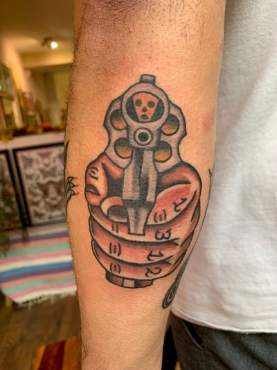Get a timeless traditional tattoo of a gun done by the talented Jakob Isaac. Bold and vibrant colors will make it stand out.