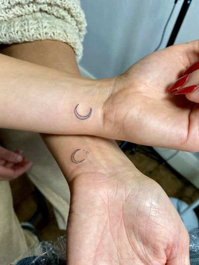 Elegant hand-poked design by Charlotte Pokes, featuring a delicate moon motif in fine lines and dots.