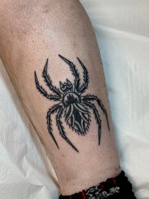 Get a classic traditional spider tattoo by skilled artist Jakob Isaac, with intricate linework and bold colors.