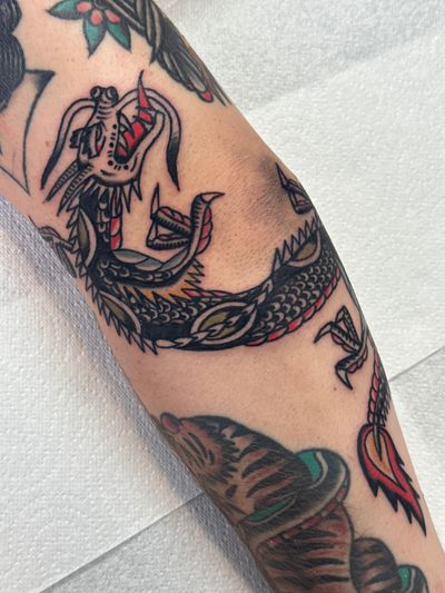 Get inked with a fierce and traditional dragon design by the talented artist Jakob Isaac. Embrace the mythical power and beauty of the dragon in this timeless tattoo.