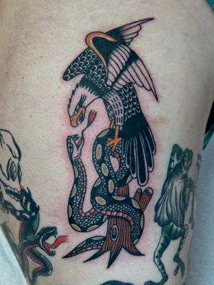 Get a stunning traditional tattoo featuring a snake and eagle design, expertly done by artist Jakob Isaac.
