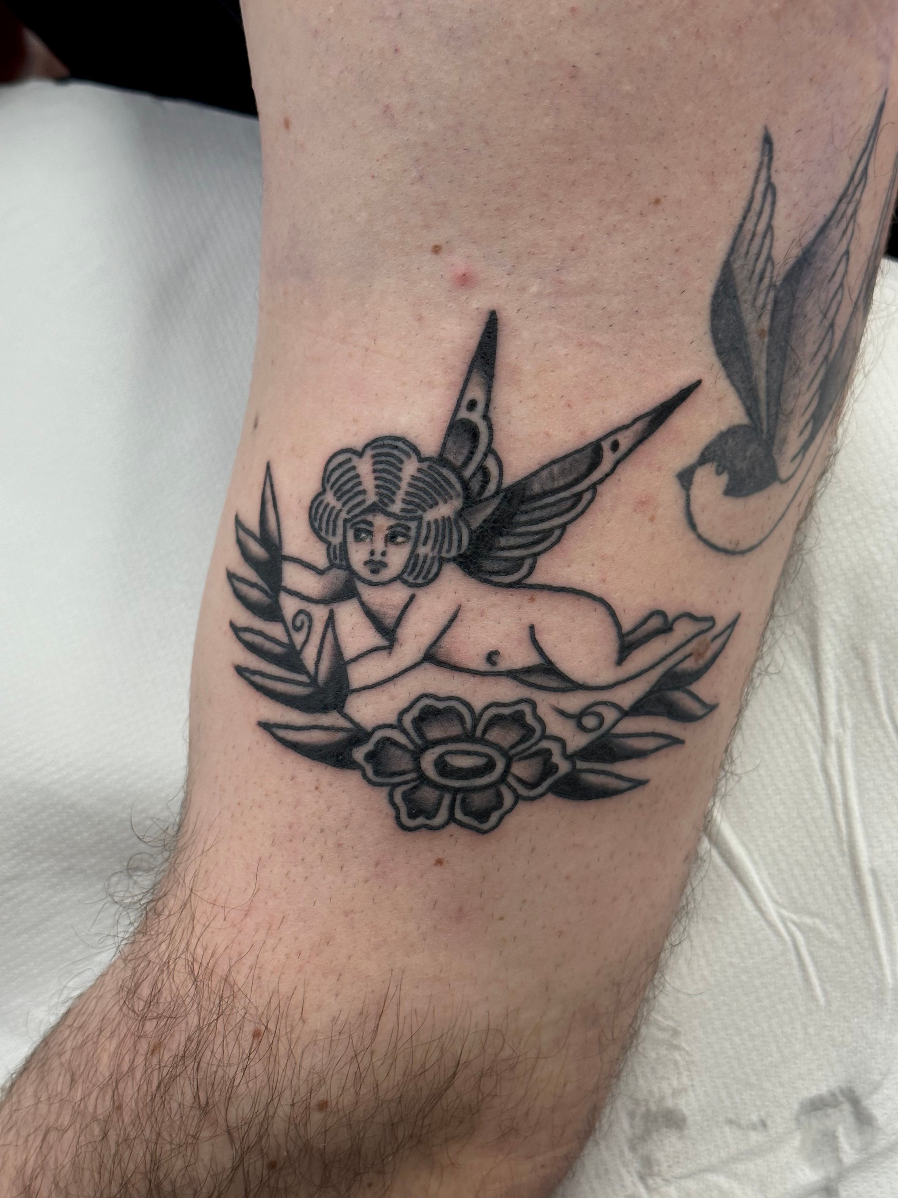 Fine line style cherub tattoo placed on the inner arm.