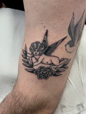 Beautiful traditional tattoo featuring a flower, angel, and cherub by artist Jakob Isaac.