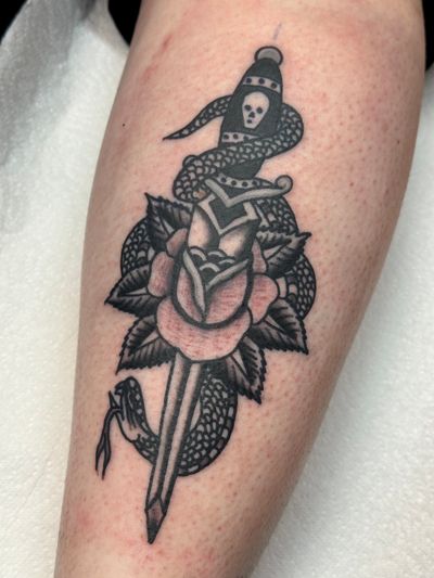 Get inked with this classic design by Jakob Isaac combining a snake, rose, and dagger in traditional style.