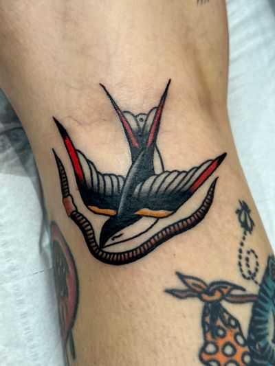 Get a timeless traditional tattoo of a swallow by the skilled artist Jakob Isaac. Perfect for those who love traditional tattoo designs.