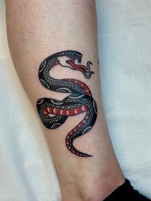 Get a classic traditional tattoo of a snake done by the talented artist Jakob Isaac. Embrace the symbol of transformation and rebirth with this unique piece.