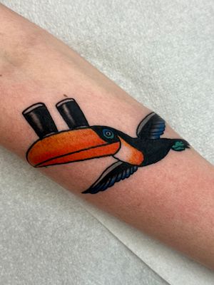 Get a vibrant and traditional toucan tattoo designed by the talented artist Jakob Isaac. Perfect for nature lovers and tattoo enthusiasts alike!