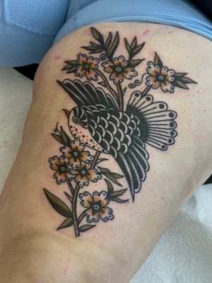 Get a stunning traditional tattoo featuring a bird and flower motif by the talented artist Jakob Isaac.