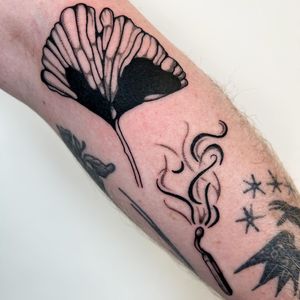 Unique and detailed tattoo design featuring a flower and match, created by the talented artist Jack Howard.