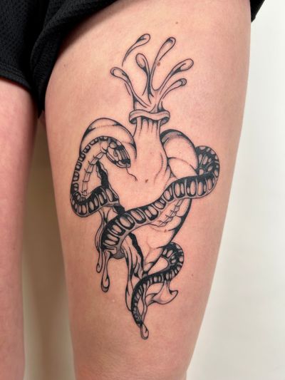 A unique and intricate tattoo design featuring a snake intertwining around a heart, created by the talented artist Jack Howard.