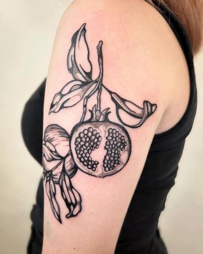 Experience the beauty of nature with this stunning botanical tattoo featuring a vibrant pomegranate design by the talented artist Jack Howard.