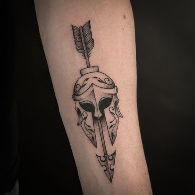 Illustrative tattoo by Jenny Dubet featuring a powerful combination of a spartan helmet and arrow design.