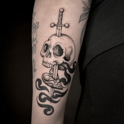 Unique tattoo combining heart, skull, and sword motifs by Jenny Dubet, perfect for those seeking a bold and edgy design.