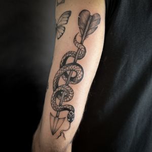Unique snake and arrow design by talented artist Jenny Dubet. Detailed illustrative style. Perfect for nature lovers and those seeking symbolic tattoos.