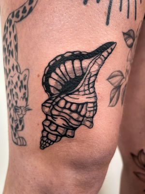 Experience the beauty of the sea with this stunning blackwork shell tattoo by artist Jack Howard. Perfect for those who love the ocean and unique body art.