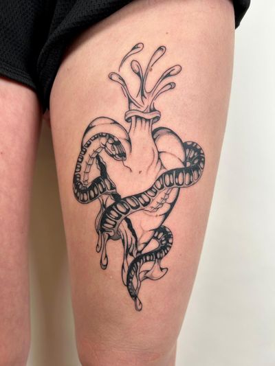 Beautifully crafted by Jack Howard, this tattoo combines a snake and heart motif in stunning blackwork style.
