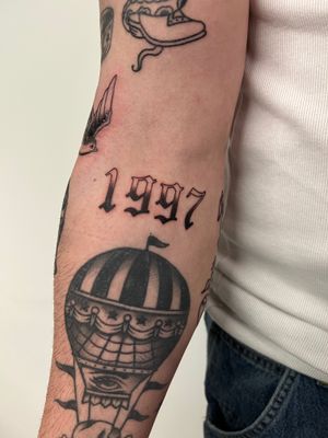 Get a timeless touch with this stunning 1997 lettering tattoo by the talented artist Kayleigh Cole. Perfect for commemorating a special year.