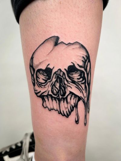 This blackwork tattoo features a skull motif in a detailed illustrative style by the talented artist Jack Howard.