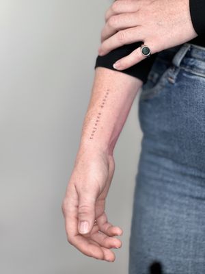 Delicate fine line tattoo with small lettering by Carolina Feodorov, featuring a meaningful quote.