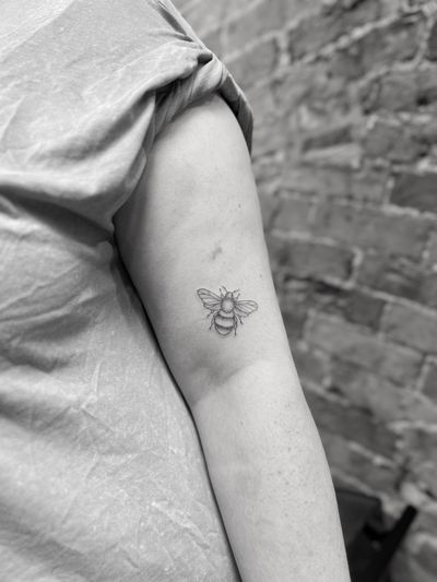 Beautiful fine line tattoo of a delicate bee, done by Aleks Fanta with intricate detailing.