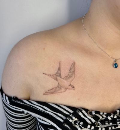 Experience the intricate beauty of hand-poked dotwork in this micro-realism design of a graceful swallow by talented artist Alina Wiltshire.