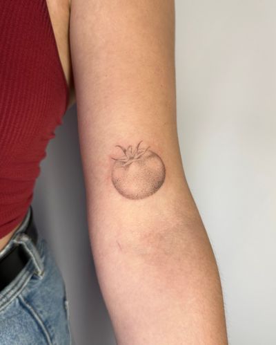 Explore the fusion of dotwork and micro-realism in this hand-poked tomato tattoo by the talented artist Alina Wiltshire.