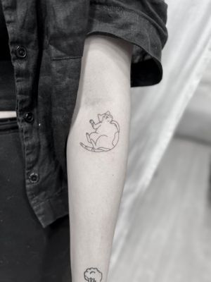 Fine line and illustrative style cat tattoo by Aleks Fanta, featuring a delicate outline design.