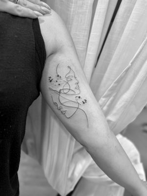 Elegantly crafted fine line and illustrative single line tattoo of a face, designed by the talented artist Aleks Fanta.