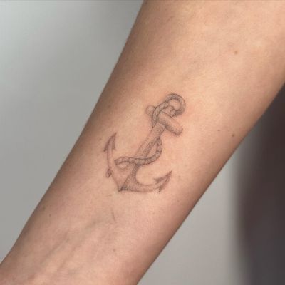 Get a unique anchor tattoo created by Alina Wiltshire using delicate dotwork and hand poke technique. Perfect for a subtle yet meaningful design.