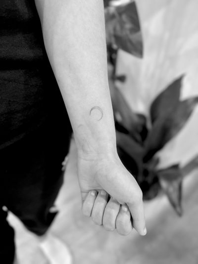 Experience the serene beauty of a delicate dotwork moon tattoo by the skilled hands of Aleks Fanta. A timeless piece of art.