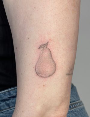 Unique dotwork style fruit tattoo of a pear by artist Alina Wiltshire, creating a lifelike and detailed design.